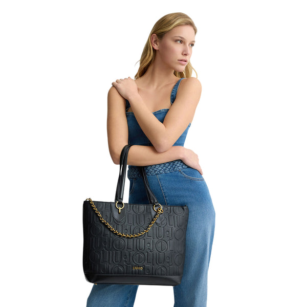 Borsa tote media Nera da donna con catena decorativa su modella