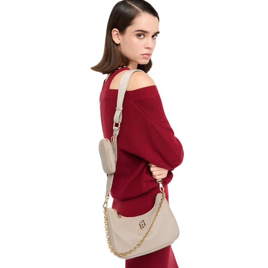 Borsa hobo piccola a tracolla beige con catena modella